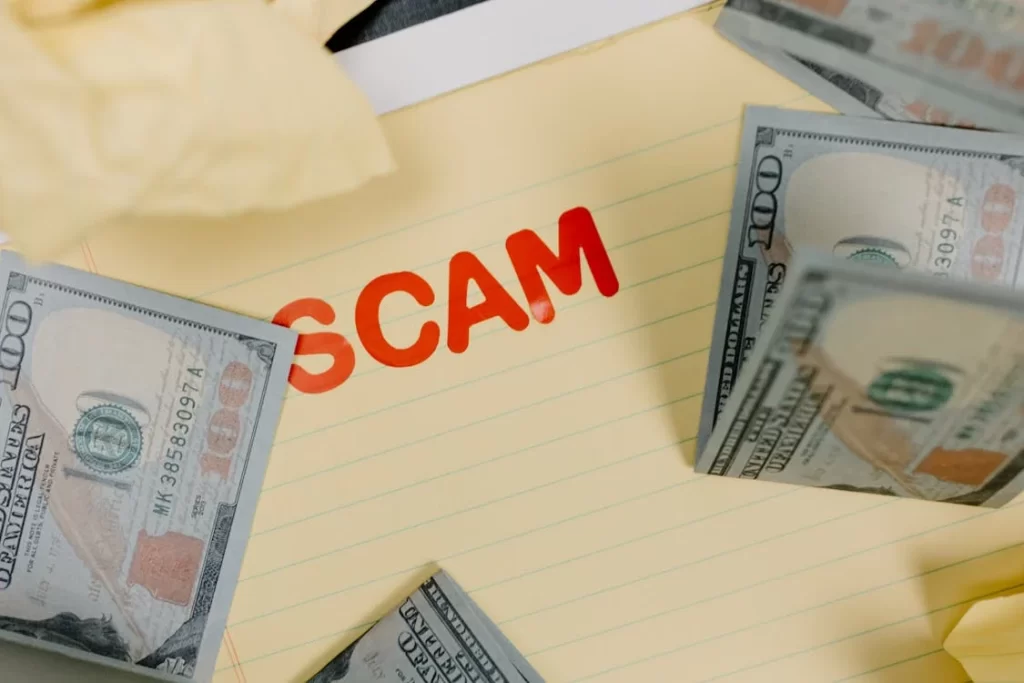 Scam written on paper with money around it